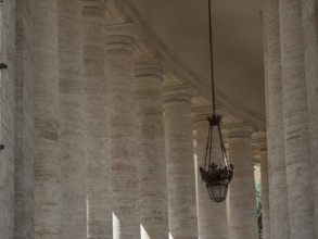Atmospheric view of columns and lanterns in classical style in the interior of the Vatican, Rome,