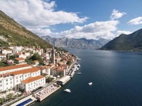 Swimming pool and private beach on the shore of the Bay of Kotor overlooking ancient houses.