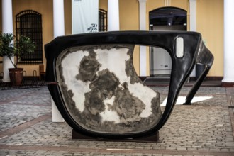 Broken horn-rimmed glasses as a work of art in memory of Salvador Allende Gossens in the courtyard
