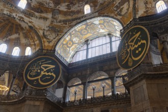 A picture of two of the calligraphic roundels inside the Hagia Sophia, in Istanbul
