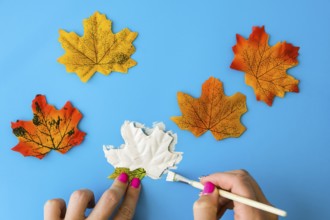 Maple leaf with painted face as decoration for autumn Halloween holiday celebration. Halloween