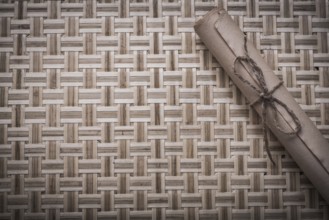 Vintage rolled corded paper on woven wooden matting