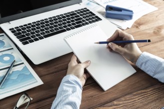 Close-up, female hands with notebook and pencil. Business woman working at the table in the office