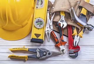 Composition of building implements leather tool belt building helmet on wooden board