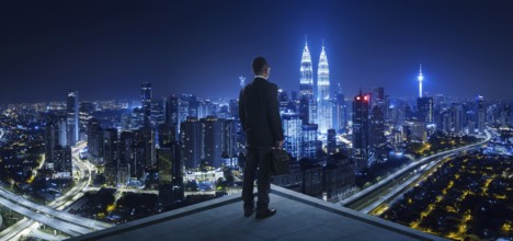 Businessman stand at rooftop looking great cityscape view and thinking business plan of the future