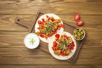 Cooking Traditional Greek Dish Gyros: Pita bread with vegetables, meat, herbs, olives on rustic