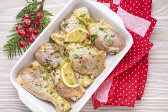 Preparing festive Christmas Eve meal with marinated chicken drumsticks. Raw chicken legs with