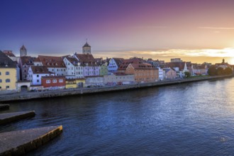 Historic cityscape of Regensburg at the river Daube during sunset