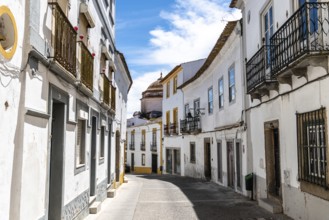 Evora, Portugal, June 30, 2022: Street in the old town with typical whitewashed houses with