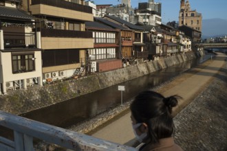 26.12.2017, Kyoto, Japan, Asia, A woman crosses a bridge over the Kamo River in Kyoto early in the
