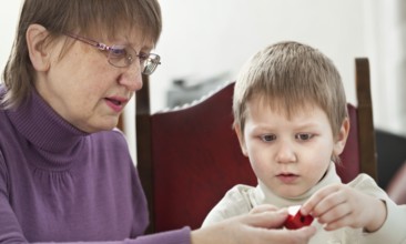 Granny is playing with her grandson at home, Belgium, Europe