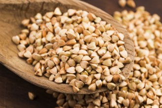 Buckwheat with a spoon on a wooden boards background