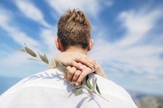 Olive branch in female hands. Hands of the bride. Wedding in Montenegro