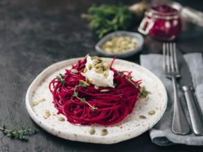 Beetroot pesto or hummus. Homemade beet pesto sauce in glass jar and fresh thyme on dark black