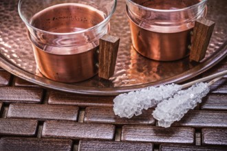 Close up view of coppery tray tea cups sugar sticks