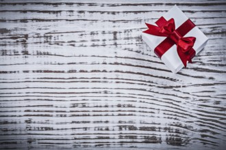 Present box with bow on vintage wooden board holidays concept