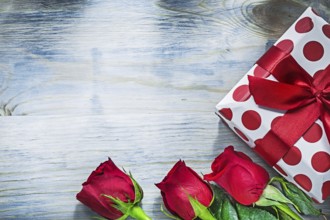 Present box red roses on wooden board holidays concept