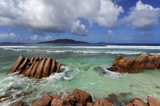 Rocks in the water at Anse Banane, with Felicite Island behind, La Digue Island, Seychelles, Indian
