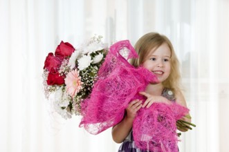 Beautiful little girl with a bouquet of flowers