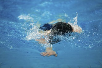 A swimmer swims in an indoor pool