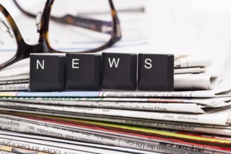 The image shows a stack of newspaper with set of letters