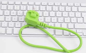 Green power plugon a keyboard isolated on white background