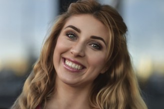 Closeup portrait of beautiful pensive blonde white Caucasian girl woman, weared in red jacket