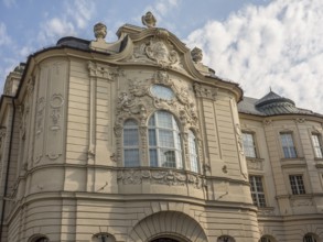 Historic building with baroque façade, elaborate reliefs and sculptures under a slightly cloudy