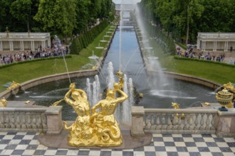 Magnificent garden fountain with golden sculptures and rising water jet, in the background