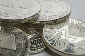 Macro photo of Ripple cryptocurrency physical coin surrounded with variety of other crypto altcoins