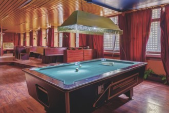 A room with a pool table in the centre, red curtains and a wooden ceiling, Bad am Park, Lost Place,