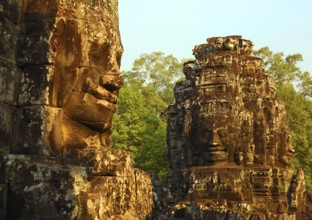 Giant stone faces at Bayon Temple at sunrise, Angkor Wat, Cambodia, Asia