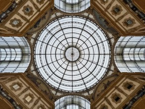 Round stained-glass windows and arches on the ceiling of the Vittorio Emmanuel Gallery. Milan,
