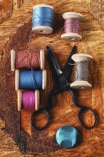 Six antiquated sewing threads and buttons on retro background