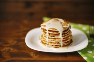 Condenced milk being poured on a stack of pancakes. High quality 4k footage