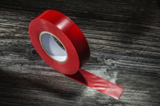 Red rolled duct tape on vintage wooden board