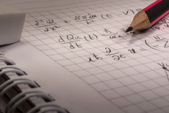 Pencil on notebook, full of mathematical formulas