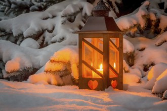A lantern shines in the snow at Christmas. Romantic light on an evening in winter. Silence and
