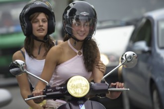 Two woman riding a scooter, Barcelona, Spaina
