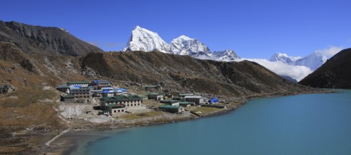 Lodges in Gokyo, turquoise lake and snow covered mountain Cholatse, Nepal, Asia