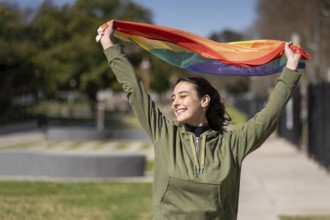 Lesbian girl waving LGBT flag with happy expression