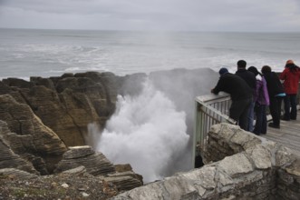PUNAKAIKI, NEW ZEALAND, MAY 5, 2010: Tourists enjoy the main blowhole in action at the Pancake