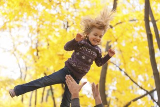 Cute little girl jumping in the autumn forest