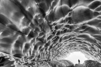 Man in an ice grotto, glacier in the Tarfaladalen valley (Darfalavaggi), Kebnekaisefjaell