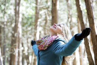 Blond casual woman happy outdoors in the woods, Toronto, Canada, North America