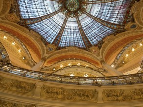 Magnificently decorated dome with colourful stained glass windows that shine in golden light, rich