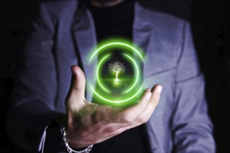 Businessman holding green tree icon. Environmental protection concept.