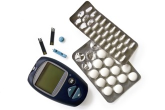 Blue instrument for measuring glucose levels with test strips, needles and pills isolated on white