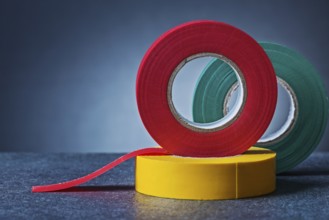Multy colored rolls of insulation tape on gradient gray background