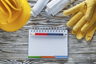 Safety gloves building helmet blueprints notepad pencil